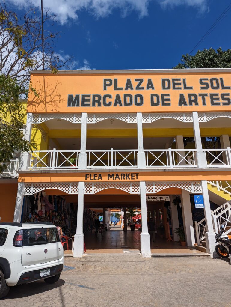 Plaza Del Sol Mercado De Artes, a bustling shopping plaza in the city center of Cozumel with breezeway views of the blue waters.