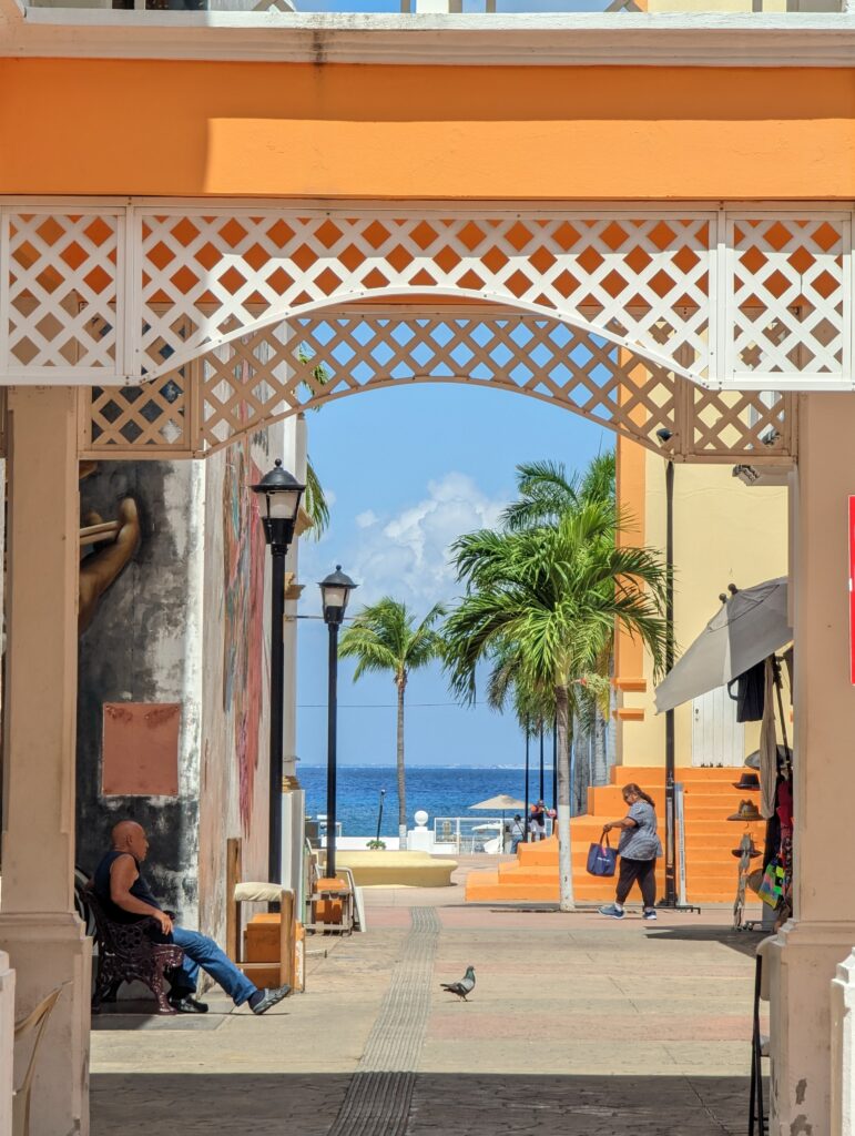 Plaza Del Sol Mercado De Artes, a bustling shopping plaza in the city center of Cozumel with breezeway views of the blue waters