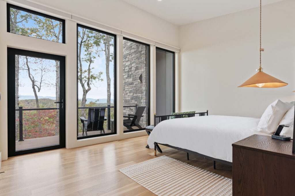 Luxurious primary bedroom at Wander Cedar Mountain with balcony overlooking breathtaking mountain views